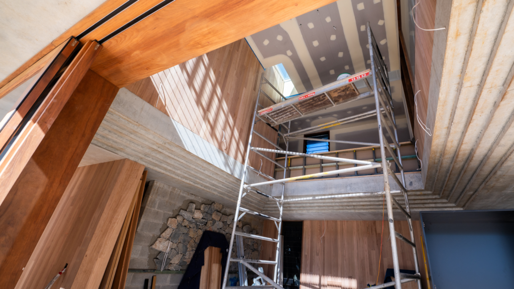 Scaffolding in a home under construction to allow workers to install skylights and plastering