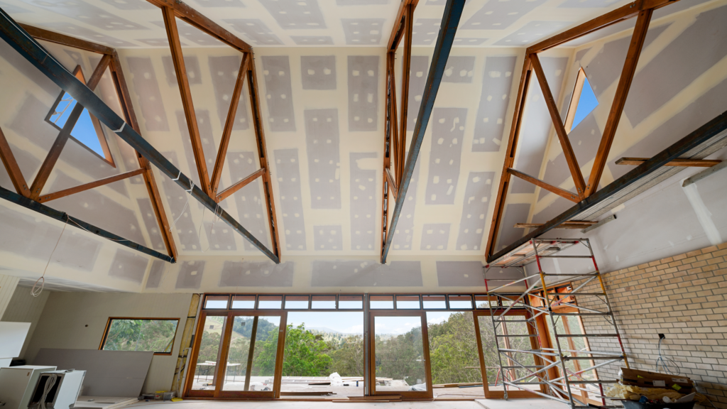 Internal view of a vaulted roof under construction with skylights.